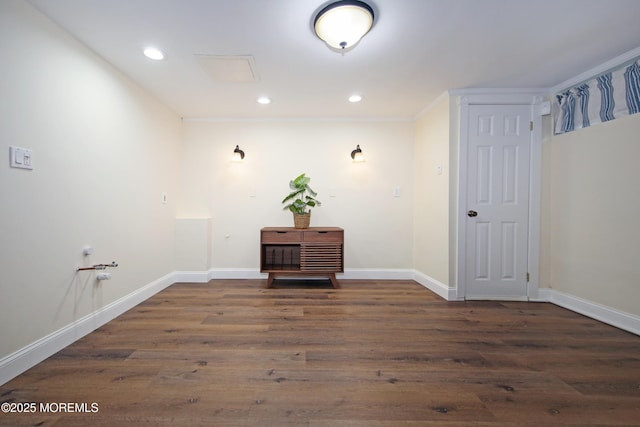 laundry area with ornamental molding and dark hardwood / wood-style floors