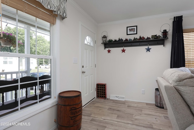 entryway featuring light wood-type flooring and ornamental molding