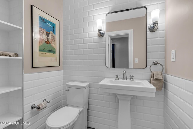 bathroom with tile walls and toilet