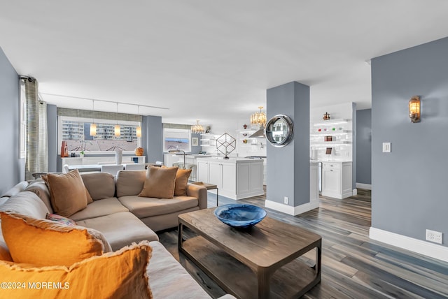 living room with a notable chandelier, rail lighting, and dark hardwood / wood-style floors