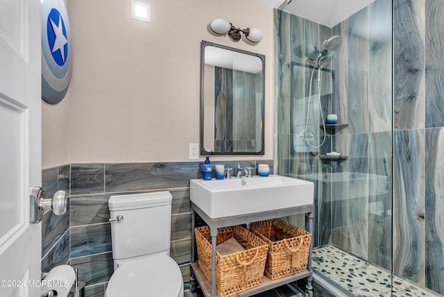 bathroom featuring tile walls, vanity, tiled shower, and toilet