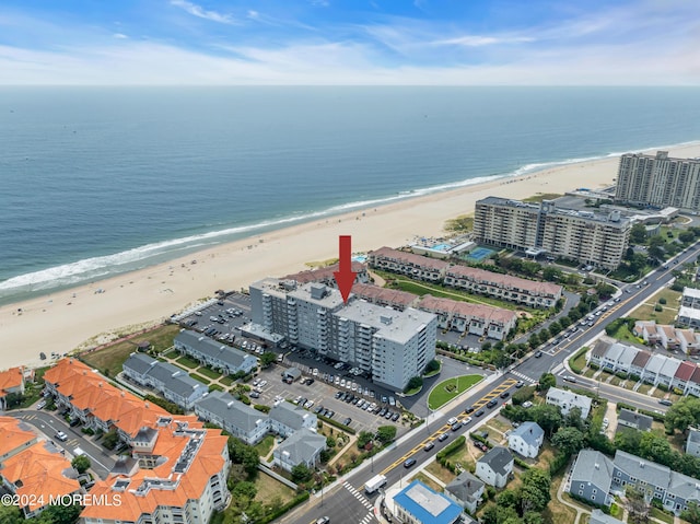 birds eye view of property with a water view and a beach view