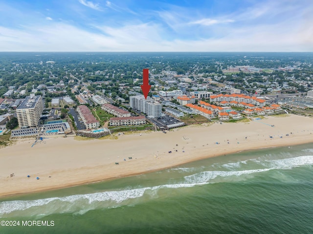 bird's eye view featuring a water view and a beach view