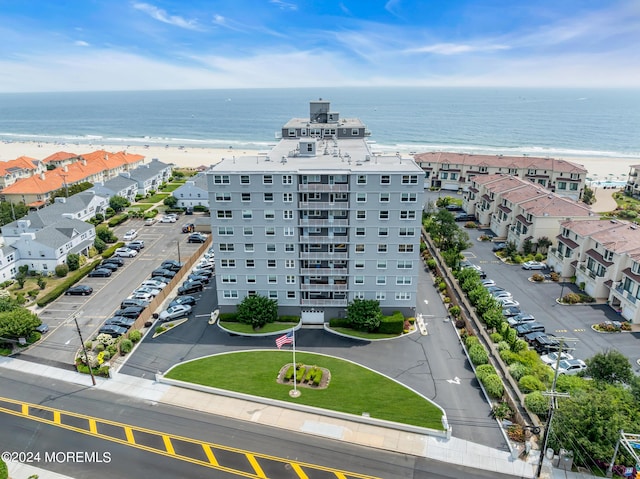 drone / aerial view with a water view and a beach view