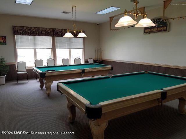 recreation room featuring a wainscoted wall, dark carpet, visible vents, and billiards