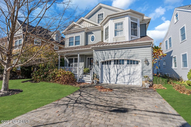 front facade with a front yard, a porch, and a garage