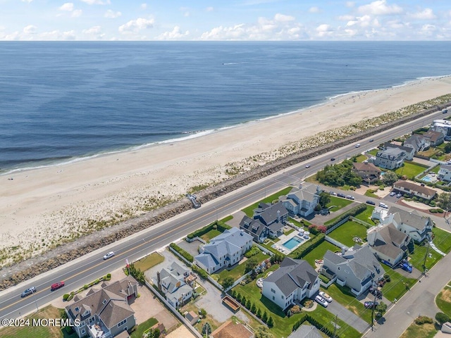 drone / aerial view with a water view and a beach view