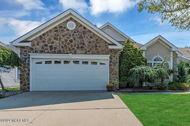 view of front facade featuring a front yard and a garage