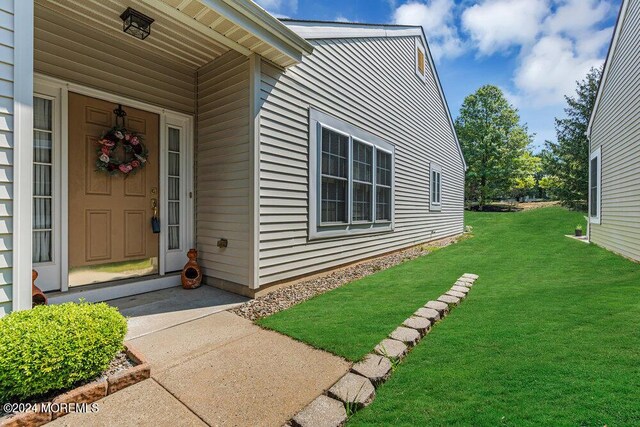 view of exterior entry with a yard