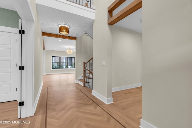 hallway featuring parquet flooring, a high ceiling, and a chandelier