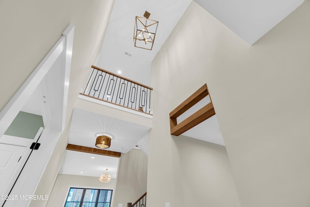 stairs featuring a high ceiling and a notable chandelier