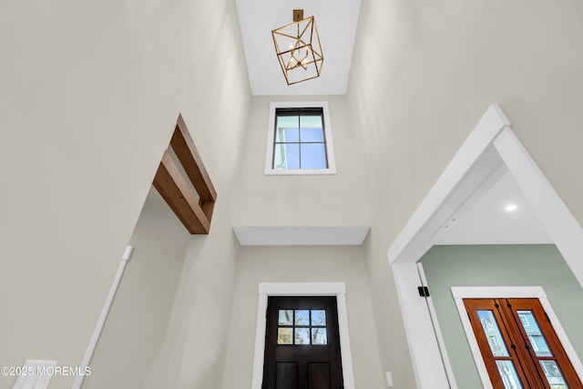 entryway with beam ceiling and an inviting chandelier