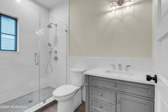 bathroom featuring toilet, tile walls, tile patterned floors, walk in shower, and vanity