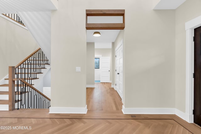 interior space featuring beam ceiling and light parquet flooring