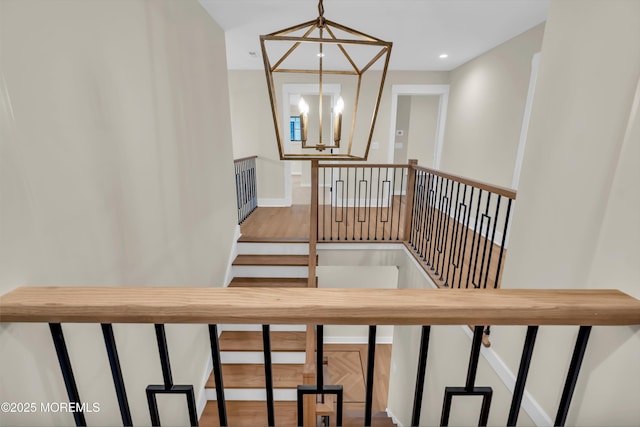 stairs with an inviting chandelier and hardwood / wood-style flooring