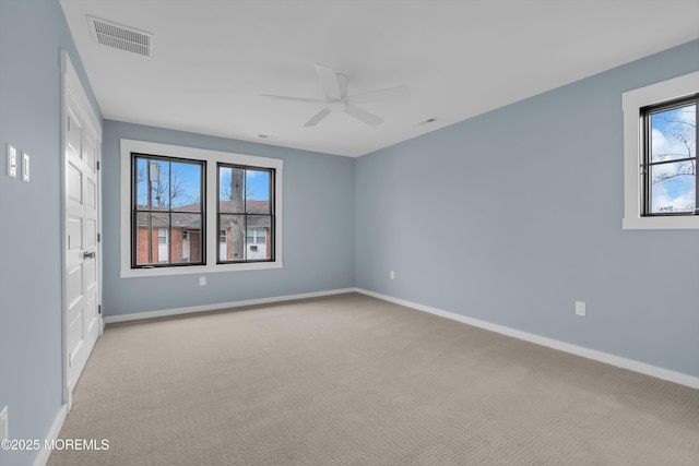 unfurnished room featuring ceiling fan, light carpet, and a healthy amount of sunlight