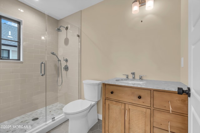 bathroom with toilet, a shower with door, vanity, and tile patterned flooring