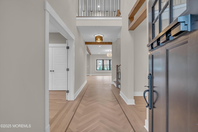 entryway featuring beam ceiling, a towering ceiling, and parquet floors