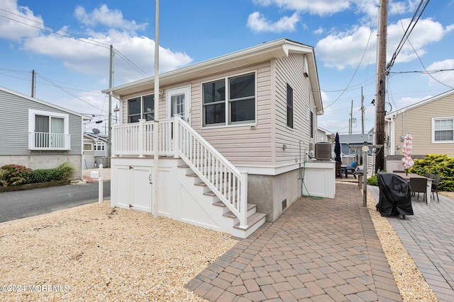 view of front facade with central AC unit and a patio area