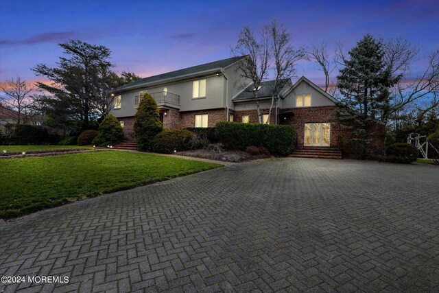 view of front property with a yard and a balcony