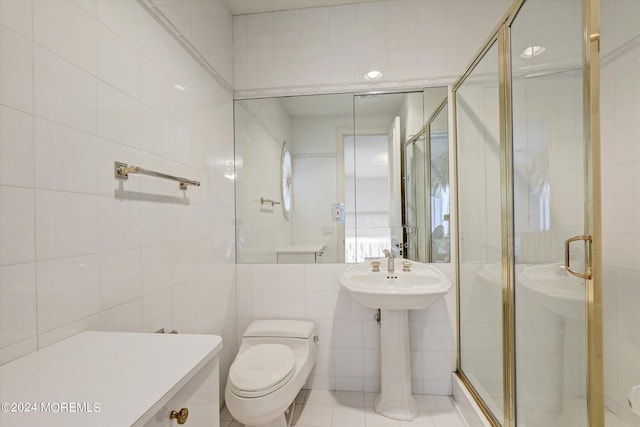 full bath with toilet, a stall shower, and tile walls