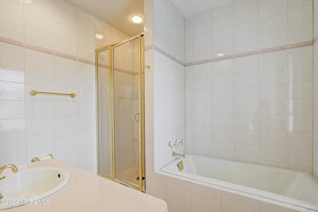 bathroom with tile walls, a sink, and tiled shower