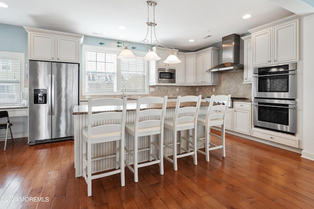52 Seaview Ave, Long Branch, NJ 07740 - kitchen with appliances with stainless steel finishes, wall chimney exhaust hood, decorative backsplash, hardwood / wood-style flooring, and pendant lighting