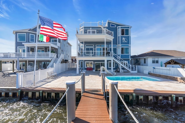 rear view of house featuring a balcony, a water view, and a patio area