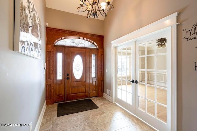 foyer entrance featuring an inviting chandelier and french doors