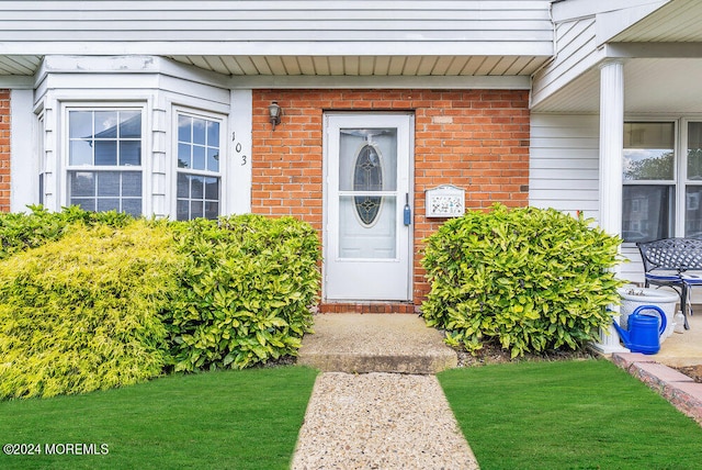 view of exterior entry with a yard