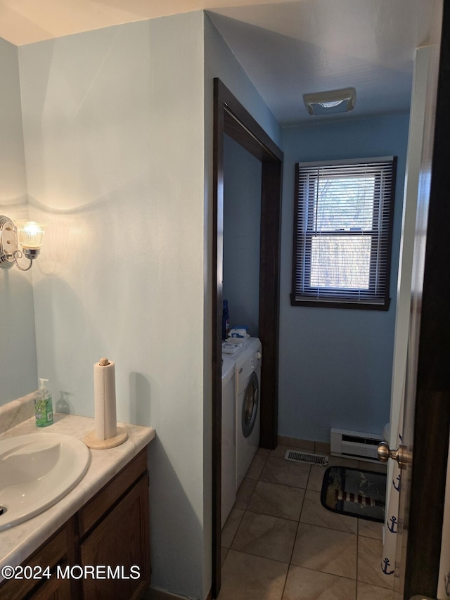 bathroom with tile patterned flooring, vanity, baseboard heating, and washing machine and clothes dryer