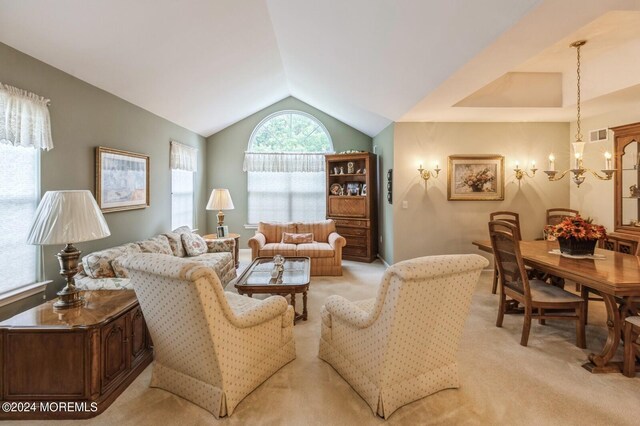 carpeted living room featuring vaulted ceiling and a chandelier