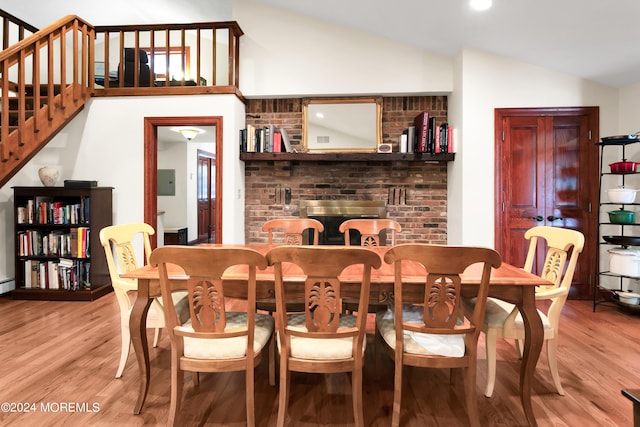 dining space with vaulted ceiling and light wood-type flooring