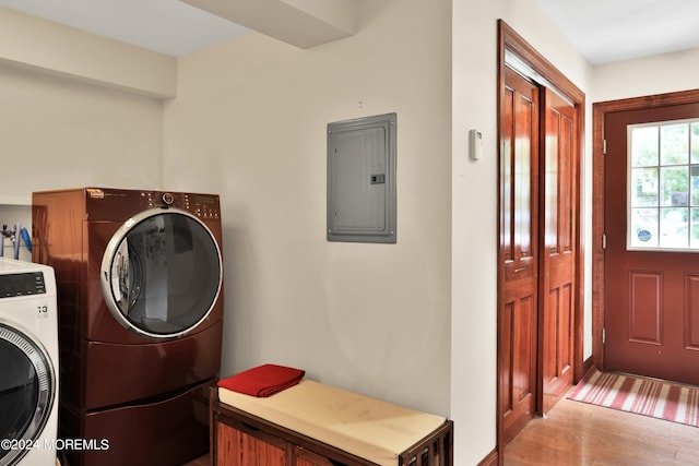 laundry area with washing machine and dryer, electric panel, and light wood-type flooring