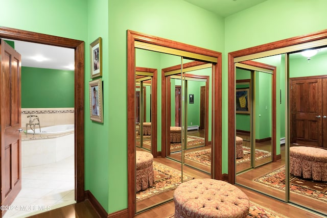 hallway featuring light hardwood / wood-style flooring and baseboard heating