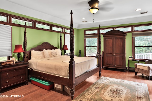 bedroom featuring ceiling fan, multiple windows, and light wood-type flooring