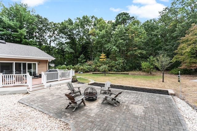 view of patio / terrace featuring a wooden deck and an outdoor fire pit