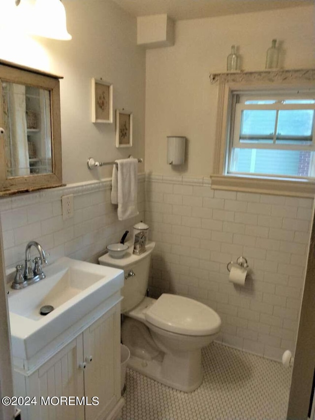 bathroom featuring tile patterned floors, toilet, tile walls, and vanity