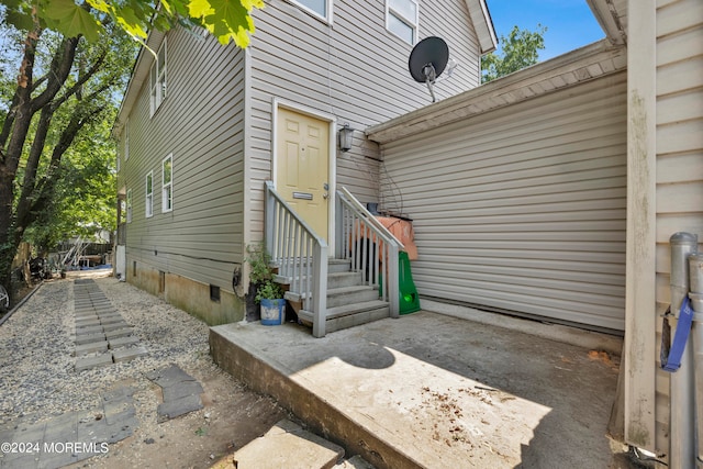 view of exterior entry with a patio area