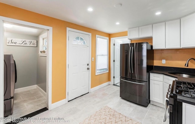 kitchen with white cabinets, light tile patterned floors, stainless steel appliances, and sink