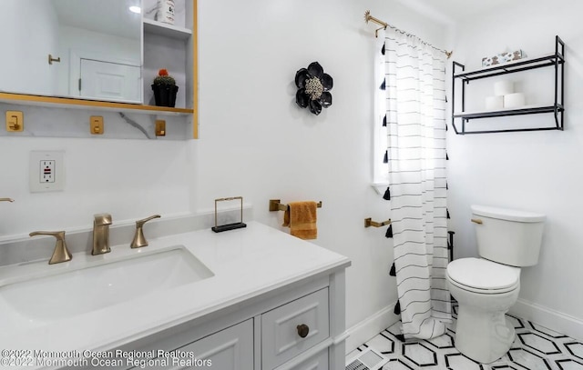 bathroom with tile patterned flooring, toilet, walk in shower, and vanity