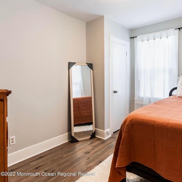 bedroom with dark wood-type flooring