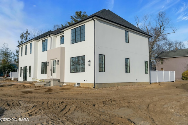 back of property featuring stucco siding and fence