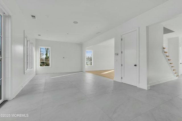 unfurnished room featuring stairway, baseboards, and visible vents