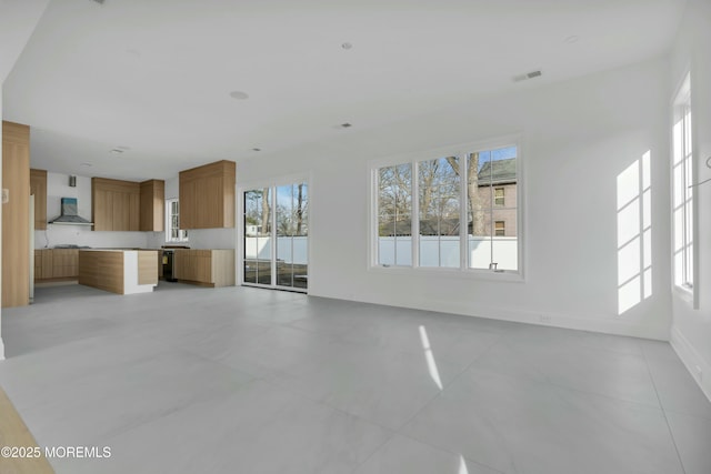 unfurnished living room featuring visible vents and baseboards