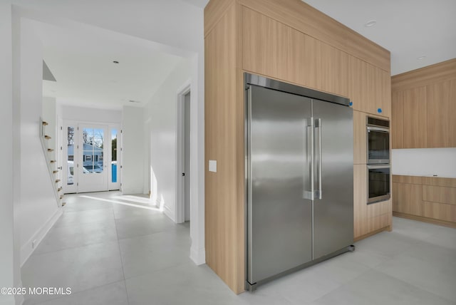 kitchen with stainless steel appliances, modern cabinets, and light brown cabinets