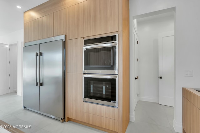 kitchen featuring modern cabinets, light brown cabinets, and stainless steel appliances