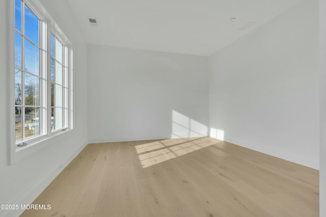 spare room with visible vents, light wood-type flooring, and baseboards