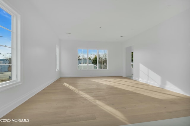 spare room with light wood-type flooring and baseboards