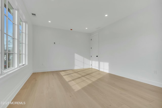 unfurnished room with recessed lighting, light wood-style flooring, visible vents, and baseboards